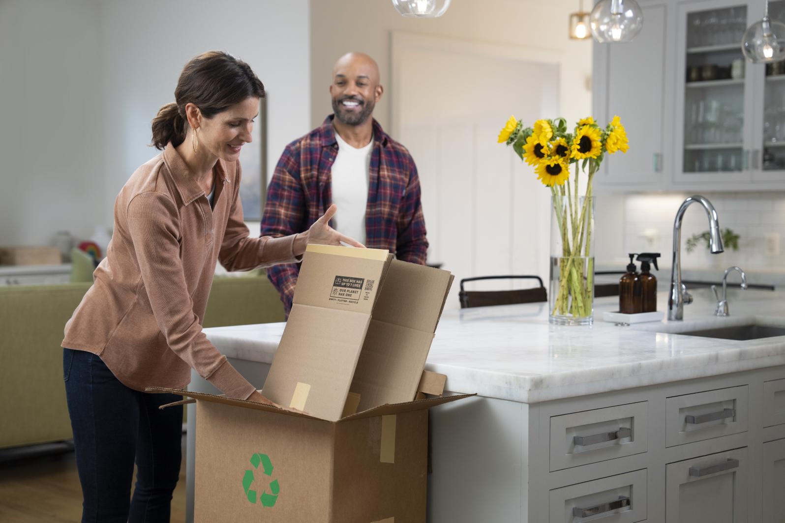 Women recycling a flattened cardboard box at home