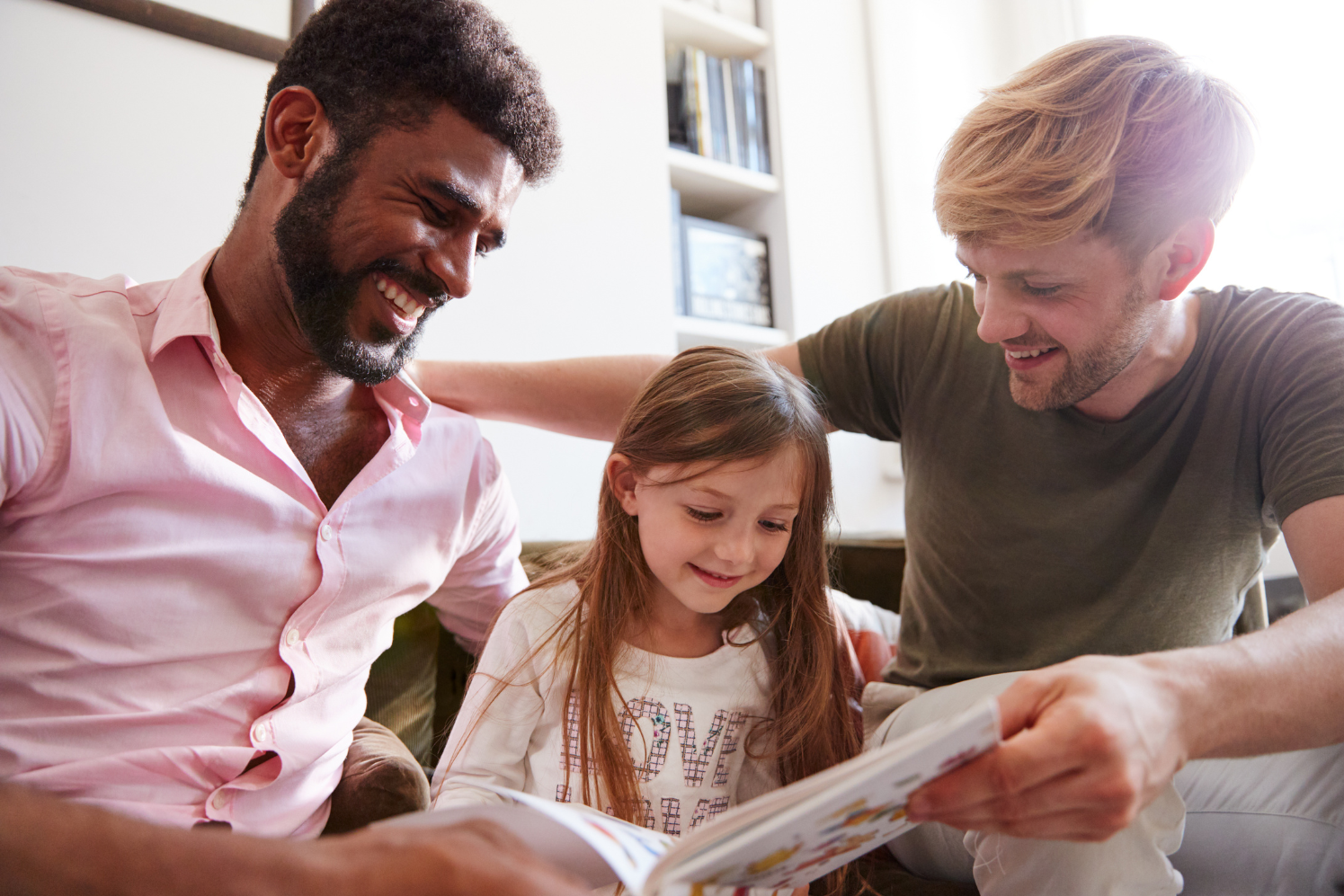 Dads reading a book to their daughter