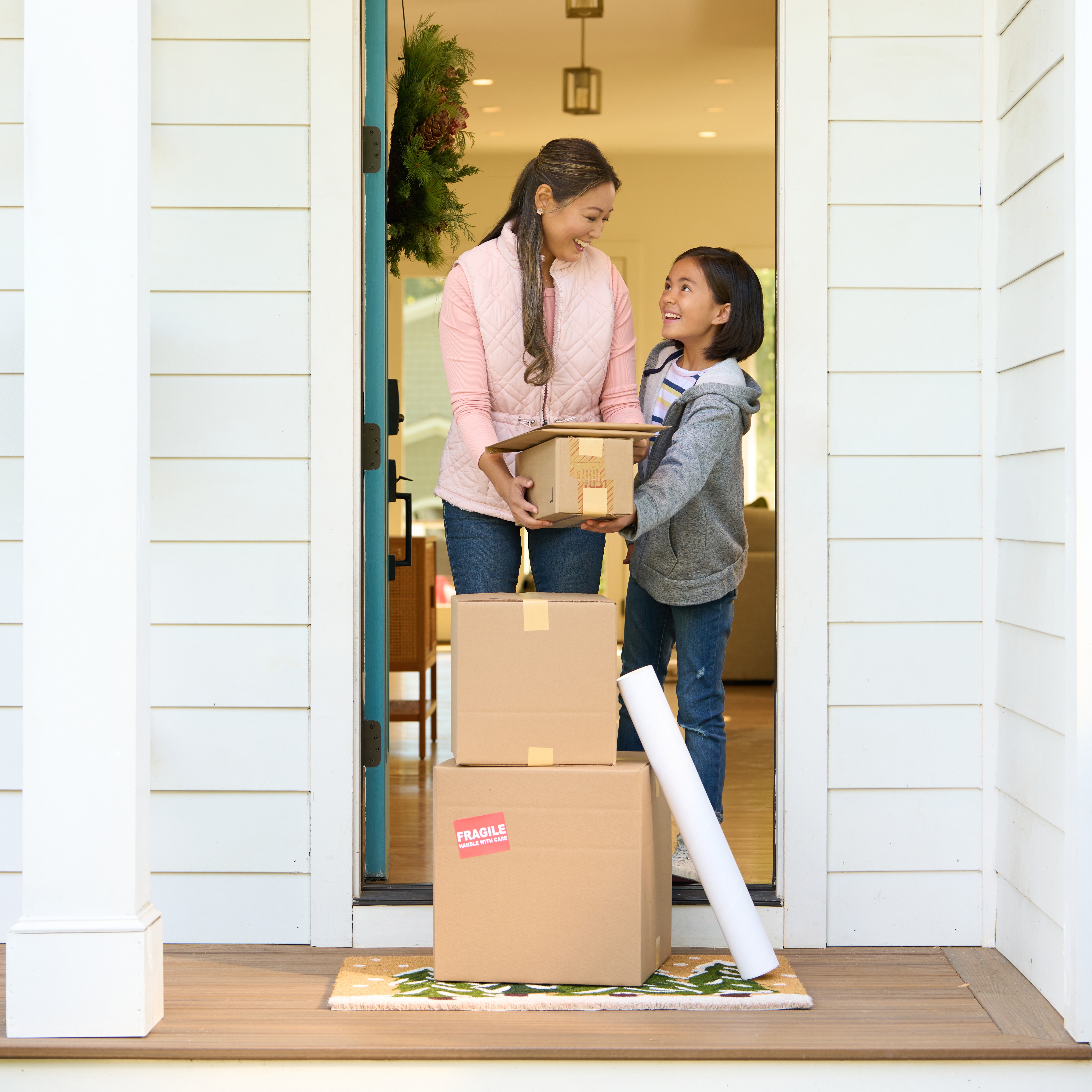 Mother and child picking up packages at their front door