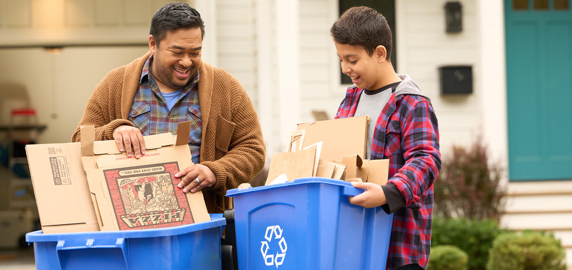 Dad and son taking out paper recycling