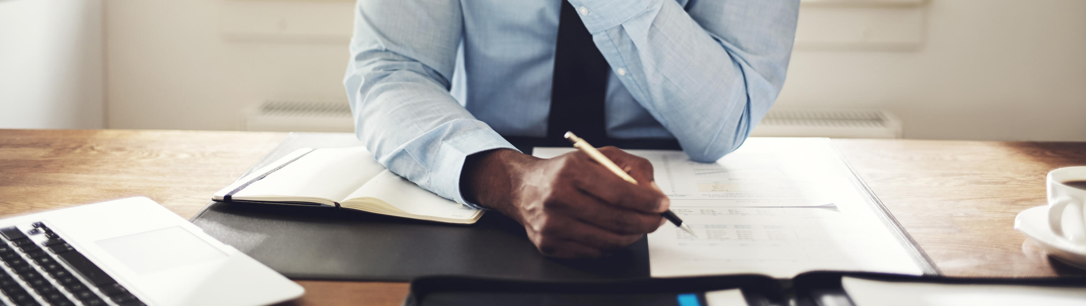 Young executive reading through paperwork at his desk