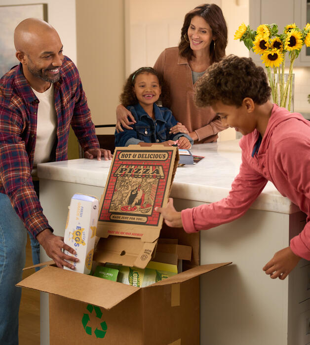 Family recycling paper products in kitchen