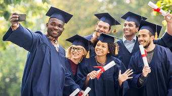 Graduates holding diplomas take selfie