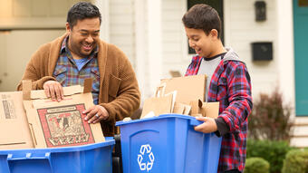 Dad and son taking out paper recycling