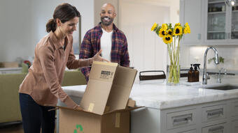 Women recycling a flattened cardboard box at home