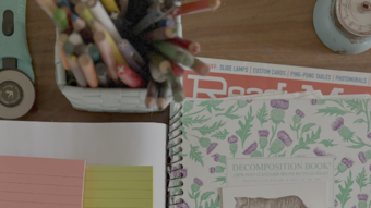 Table with notebooks, books, pens and a blue timer