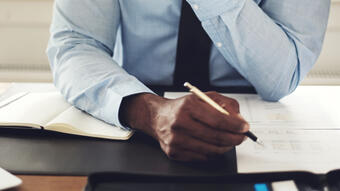 Young executive reading through paperwork at his desk