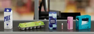 Products in paper packaging like a milk carton and deodorant in paper tube on a converbelt